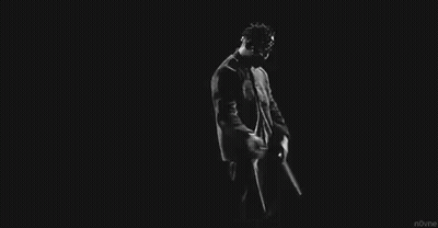 A Black And White Photo Of A Man In A Suit And Tie Dancing In The Dark . GIF