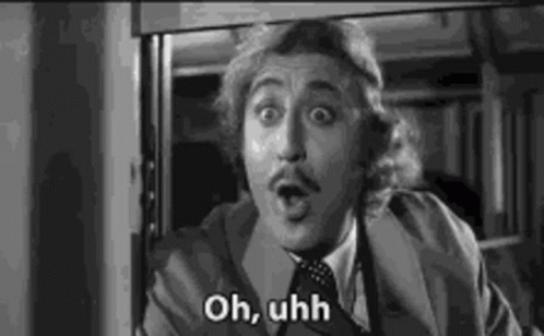 A Black And White Photo Of A Man In A Suit And Tie Making A Funny Face . GIF