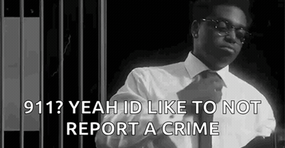 A Black And White Photo Of A Man In A Suit And Tie Standing In Front Of A Jail Cell . GIF