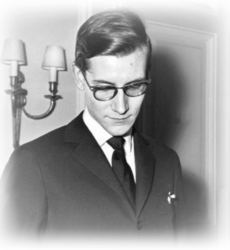 A Black And White Photo Of A Man In A Suit And Tie With Glasses GIF
