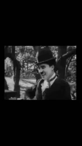 A Black And White Photo Of A Man In A Suit And Top Hat . GIF