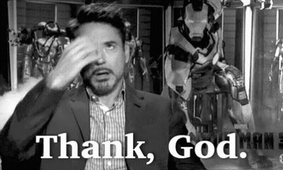 A Black And White Photo Of A Man In A Suit Covering His Face With His Hand And Saying `` Thank God '' . GIF