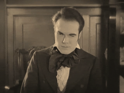 A Black And White Photo Of A Man In A Suit GIF