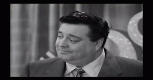 A Black And White Photo Of A Man In A Suit GIF