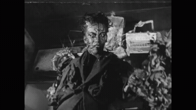 A Black And White Photo Of A Man In A Suit With His Face Painted GIF