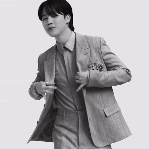 A Black And White Photo Of A Man In A Suit With His Jacket Open GIF