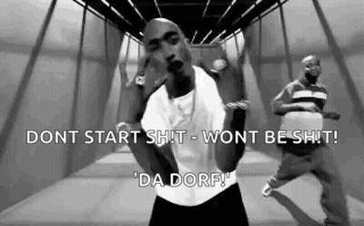 A Black And White Photo Of A Man In A White Shirt Dancing In A Hallway . GIF