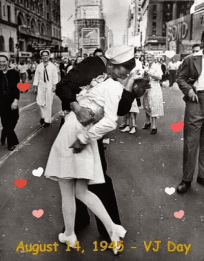A Black And White Photo Of A Man Kissing A Woman On A City Street GIF