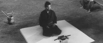 A Black And White Photo Of A Man Kneeling On A Mattress GIF