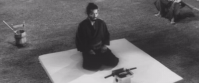 A Black And White Photo Of A Man Kneeling On A White Mat GIF