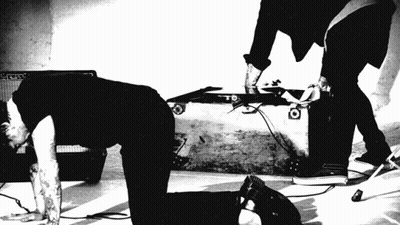A Black And White Photo Of A Man Kneeling On The Floor GIF