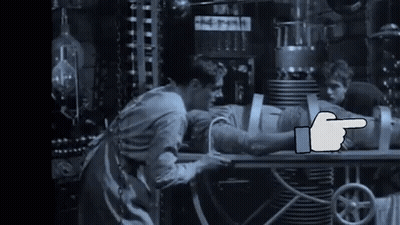 A Black And White Photo Of A Man Laying On A Table With A Hand Pointing GIF