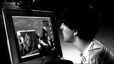 A Black And White Photo Of A Man Looking At A Computer Screen That Says 257 GIF