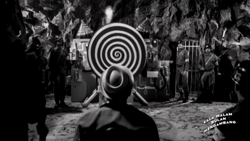 A Black And White Photo Of A Man Looking At A Target That Says Kala Malam Mengambang On It GIF