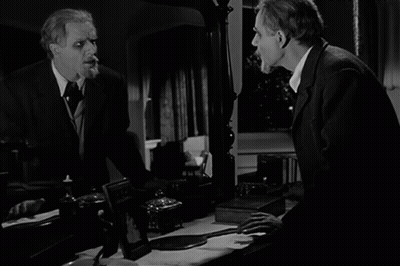 A Black And White Photo Of A Man Looking At Himself In The Mirror GIF