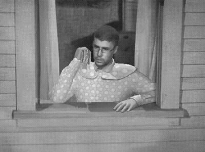 A Black And White Photo Of A Man Looking Out Of A Window With A Dollar Bill In His Hand GIF