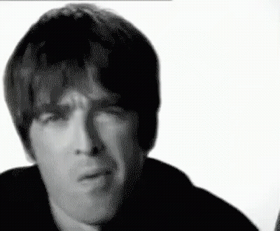 A Black And White Photo Of A Man Making A Funny Face With His Hand On His Chin . GIF