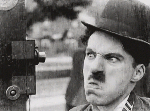 A Black And White Photo Of A Man Making A Funny Face . GIF
