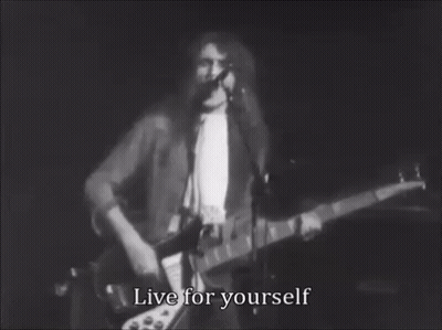 A Black And White Photo Of A Man Playing A Guitar And Singing Into A Microphone With The Words Live For Yourself . GIF