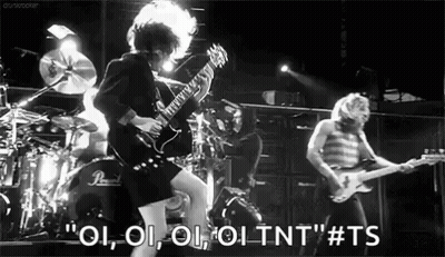 A Black And White Photo Of A Man Playing A Guitar In Front Of A Drum Set . GIF