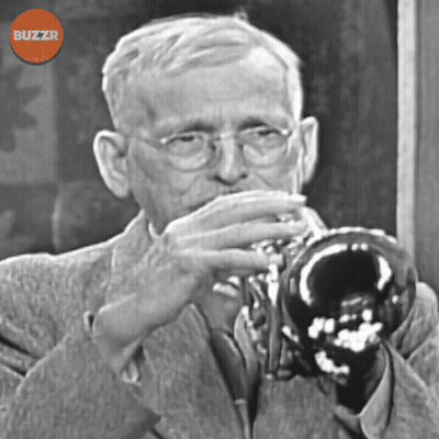 A Black And White Photo Of A Man Playing A Trumpet With A Buzzr Logo Above Him GIF