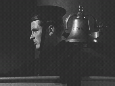 A Black And White Photo Of A Man Ringing A Bell That Says Titanic GIF