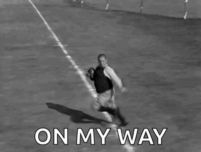 A Black And White Photo Of A Man Running With A Football With The Words On My Way Below Him GIF