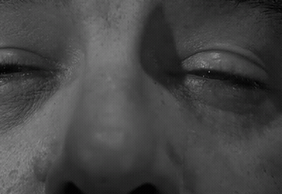 A Black And White Photo Of A Man 'S Eyes With A Shadow On His Face GIF