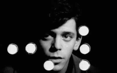 A Black And White Photo Of A Man 'S Face Surrounded By Circles . GIF