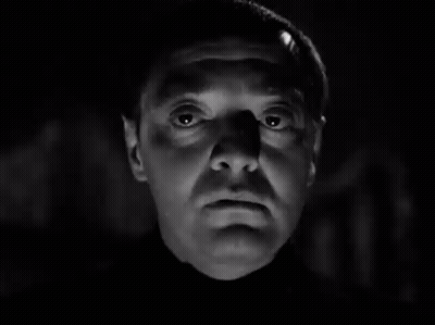 A Black And White Photo Of A Man 'S Face With A Shadow On His Forehead . GIF