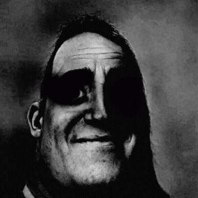 A Black And White Photo Of A Man 'S Face With A Shadow On It . GIF