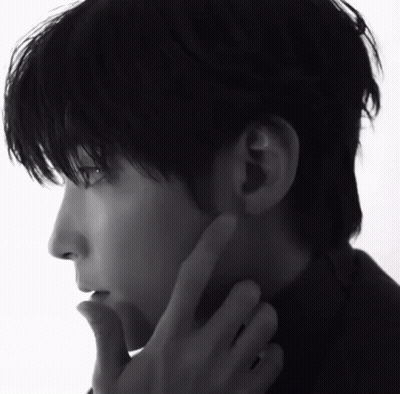A Black And White Photo Of A Man 'S Face With His Hand On His Chin GIF