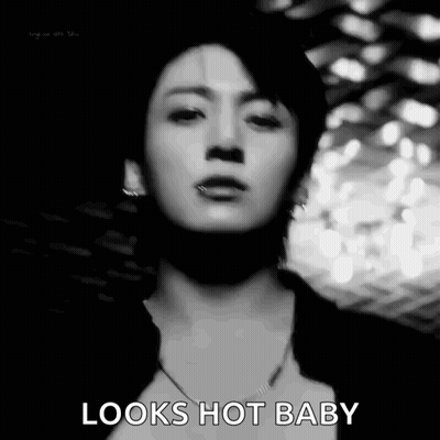 A Black And White Photo Of A Man 'S Face With The Words `` Looks Hot Baby '' Written On It . GIF