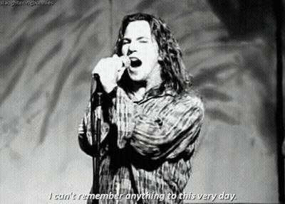 A Black And White Photo Of A Man Singing Into A Microphone GIF