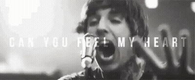 A Black And White Photo Of A Man Singing Into A Microphone With The Words Can You Feel My Heart Above Him GIF