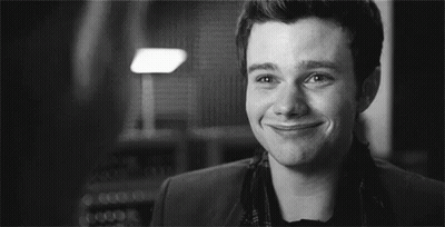 A Black And White Photo Of A Man Smiling In A Room . GIF