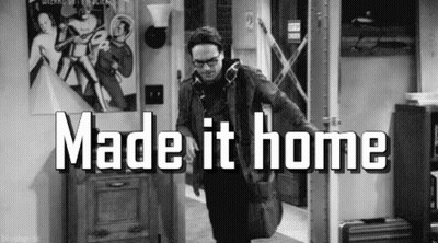 A Black And White Photo Of A Man Standing In A Hallway With The Words `` Made It Home '' Written On It . GIF