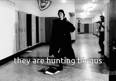 A Black And White Photo Of A Man Standing In A Hallway With The Words They Are Hunting Bingus GIF