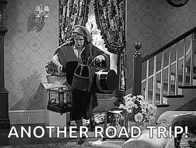 A Black And White Photo Of A Man Standing In A Living Room Holding A Bucket And A Dog . GIF
