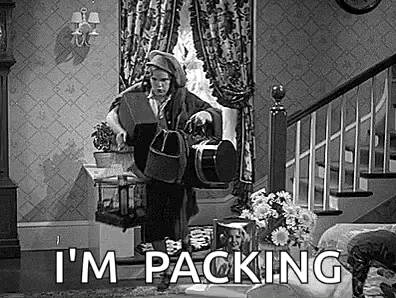A Black And White Photo Of A Man Standing In A Living Room Holding A Bucket . GIF