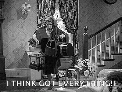 A Black And White Photo Of A Man Standing In A Living Room Holding A Drum . GIF