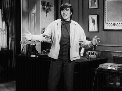 A Black And White Photo Of A Man Standing In A Room GIF