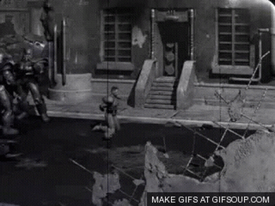 A Black And White Photo Of A Man Standing In Front Of A Building With The Words Make Gifs At Gifsoup.com Below It GIF