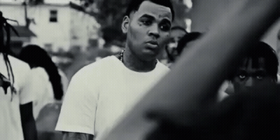 A Black And White Photo Of A Man Standing In Front Of A Crowd Of People . GIF