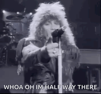 A Black And White Photo Of A Man Standing In Front Of A Microphone . GIF