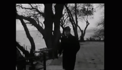 A Black And White Photo Of A Man Standing In Front Of Trees With Trt Written On The Bottom GIF