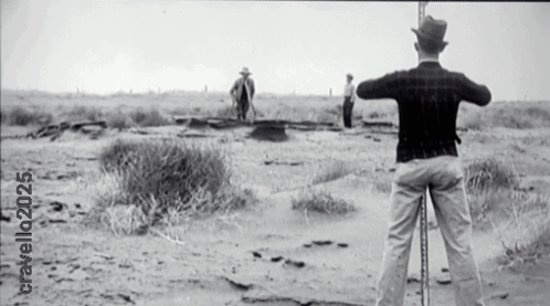 A Black And White Photo Of A Man Standing In The Desert With The Year 2025 GIF