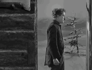 A Black And White Photo Of A Man Standing On Stairs . GIF