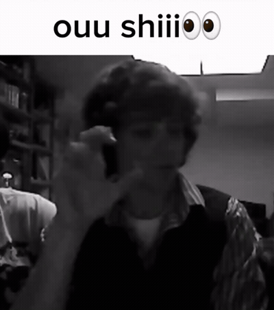 A Black And White Photo Of A Man Talking On A Cell Phone With The Words Ouu Shiii Above Him GIF
