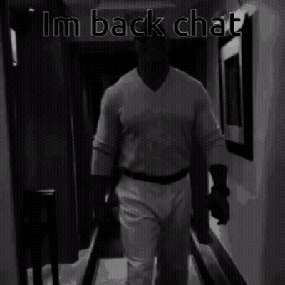 A Black And White Photo Of A Man Walking Down A Hallway With The Words Im Back Chat Above Him GIF